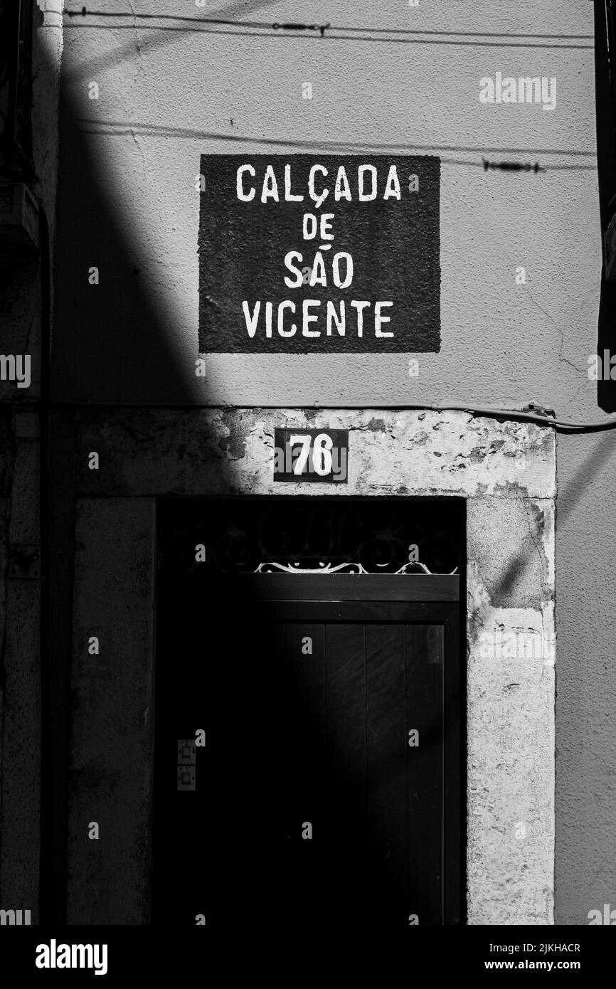 Una scala di grigi verticale di una porta di casa a Lisbona, Calcada de Sao Vicente Foto Stock