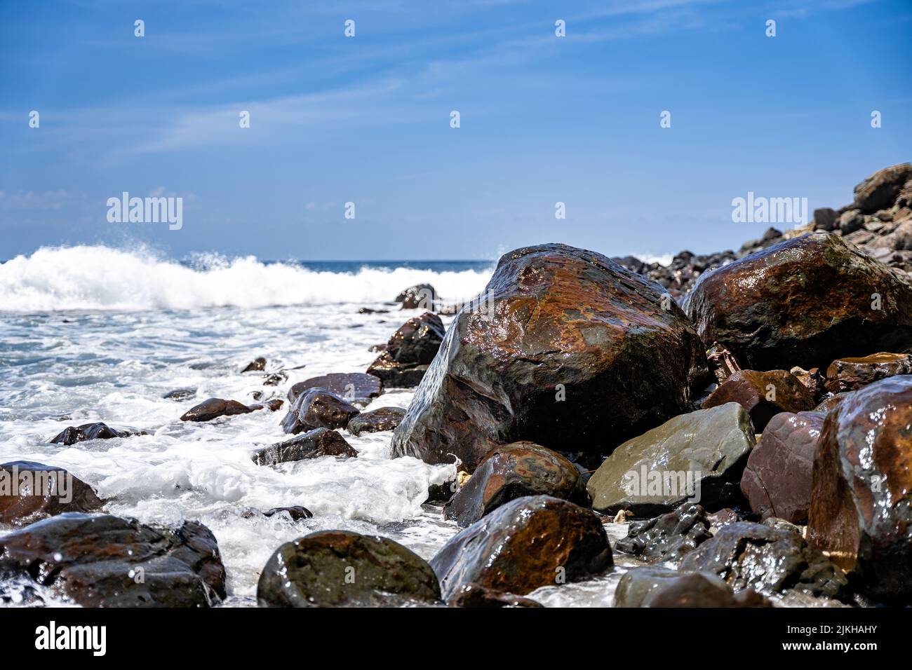 Un primo piano di onde di mare che si schiantano contro una costa rocciosa Foto Stock