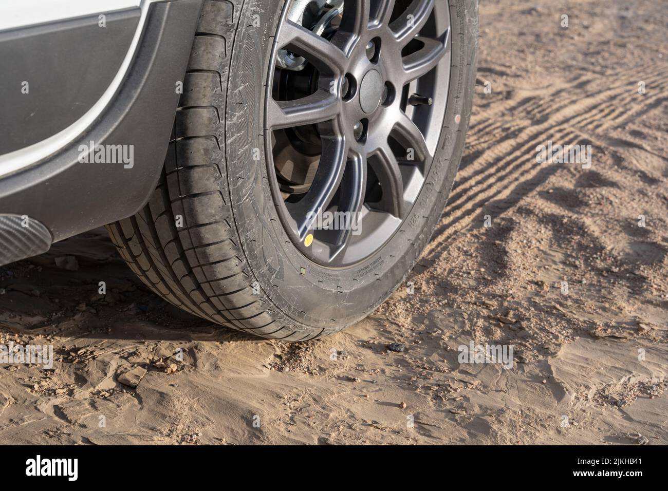 Una ruota con le sue auto sentieri sulla sabbia Foto Stock