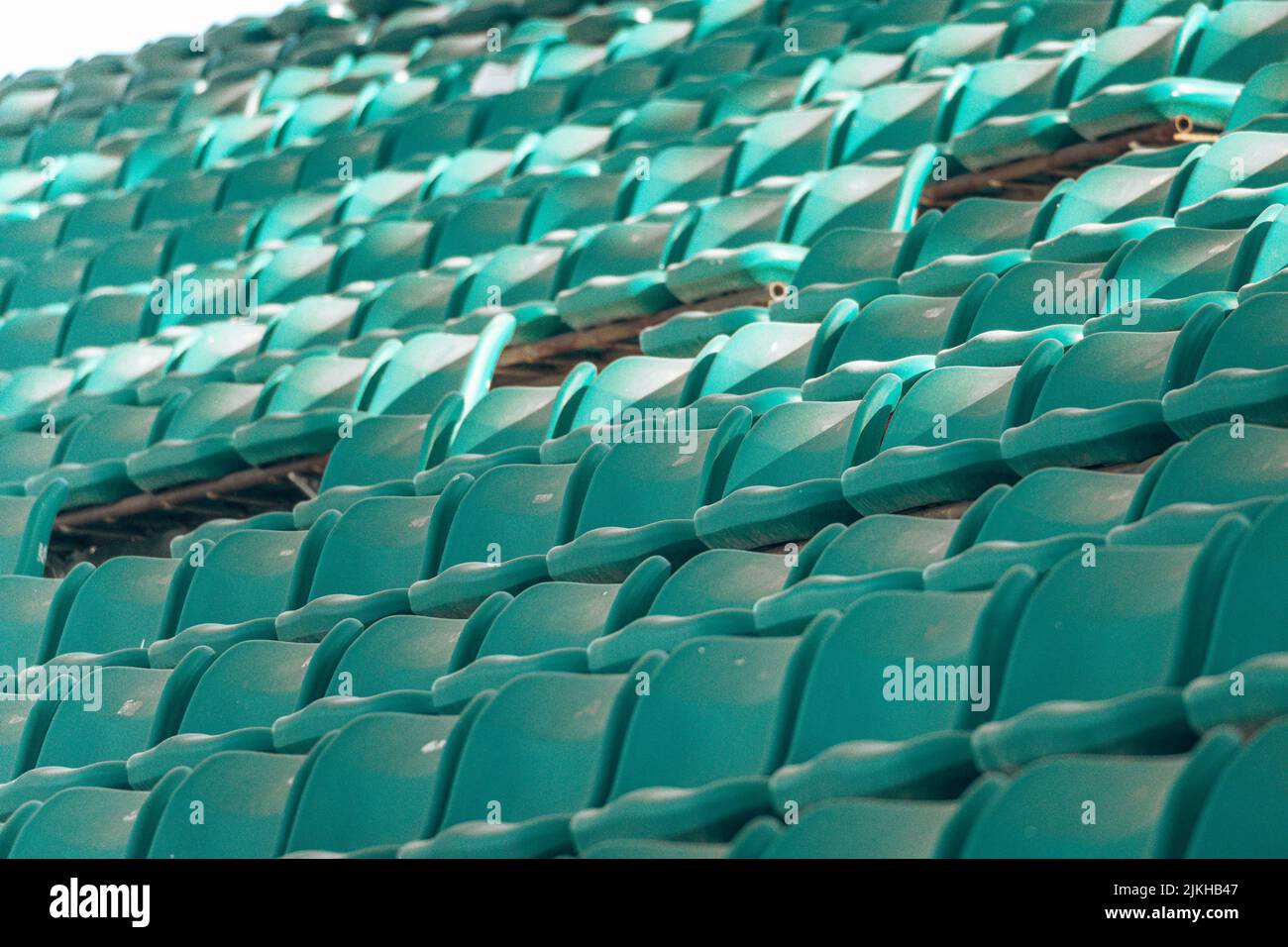 Molte grandi file blu allineate di sedili vuoti dello stadio Foto Stock