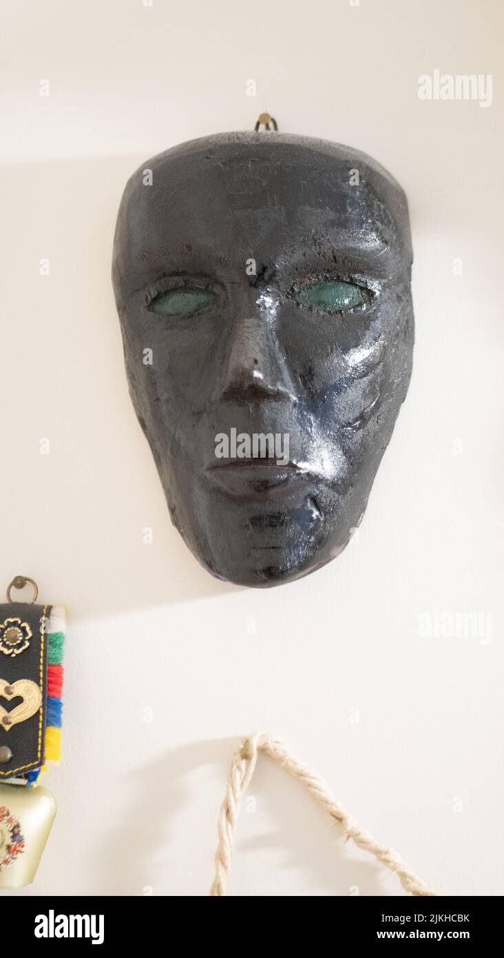 maschera di legno nera su sfondo grigio. primo piano Foto Stock