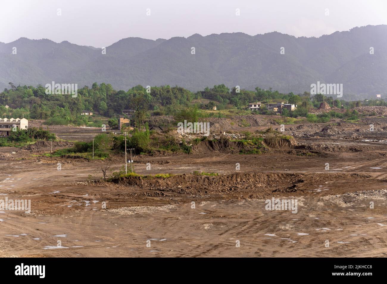 Un terreno roccioso in discesa sullo sfondo di montagne boschive Foto Stock