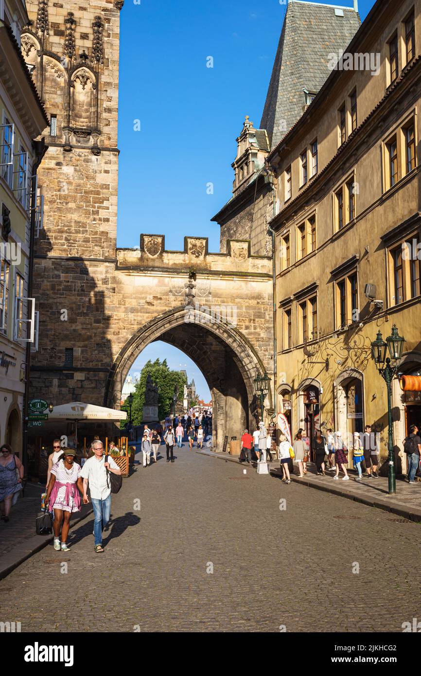 Uno scatto verticale di turisti che camminano attraverso l'arco vicino al Ponte Carlo a Praga, Repubblica Ceca Foto Stock
