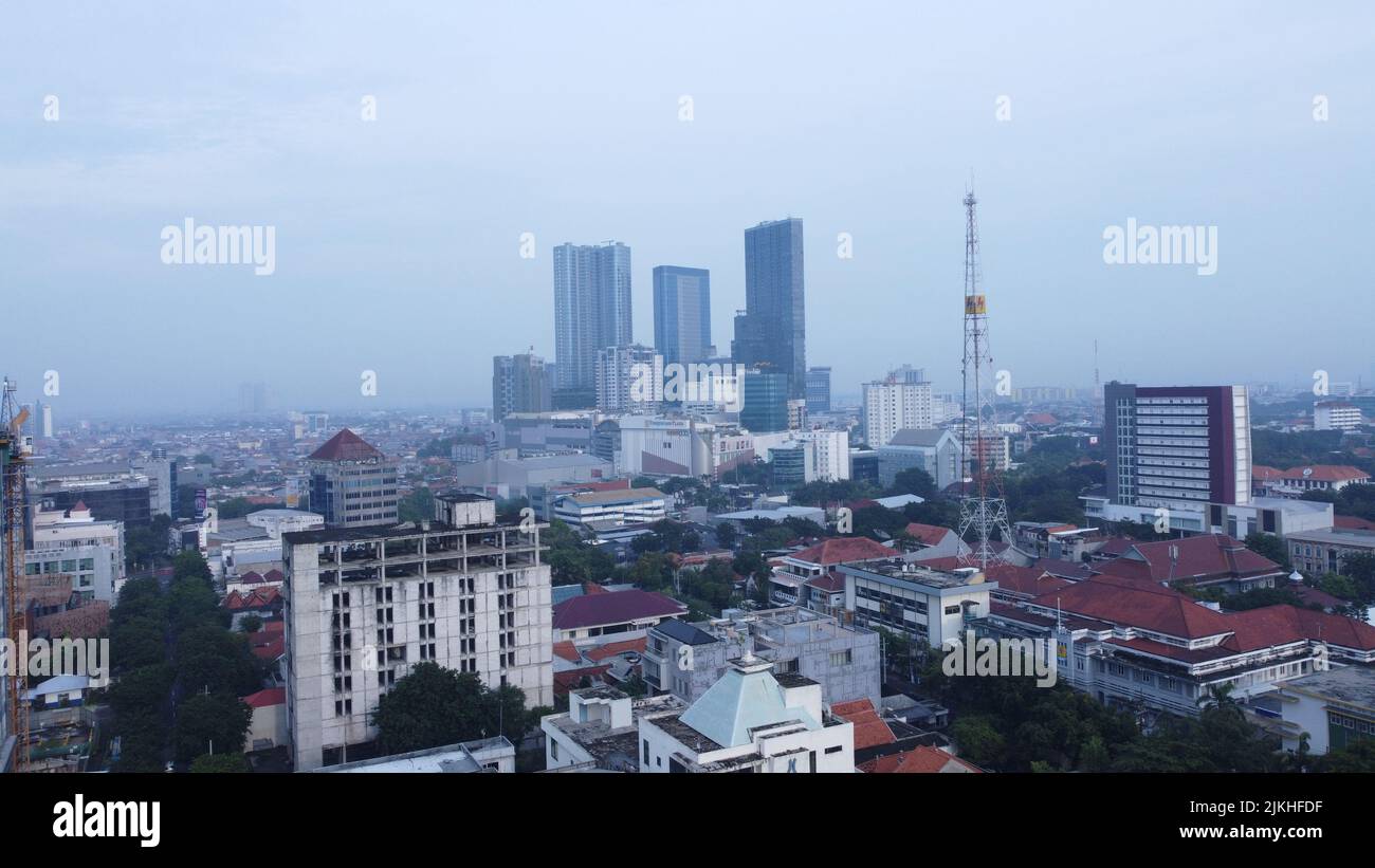Il paesaggio urbano mattutino della città di Surabaya, del centro cittadino e dei grattacieli con il tempo nuvoloso nella stagione delle piogge Foto Stock