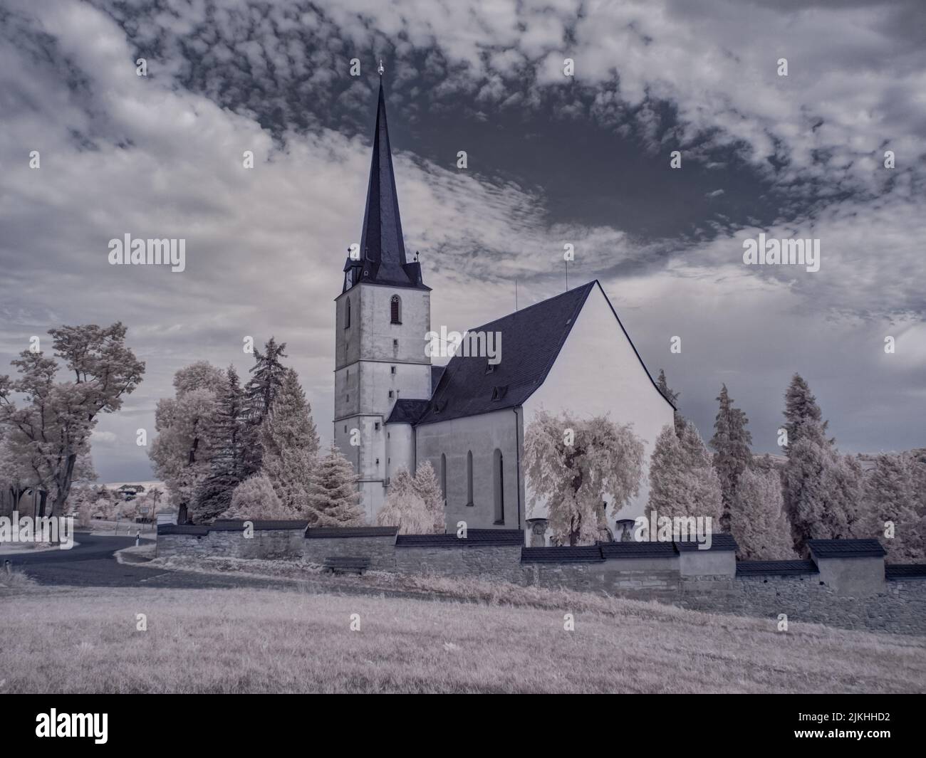 Una vecchia chiesa abbandonata in bianco e nero nella campagna sotto il cielo nuvoloso Foto Stock