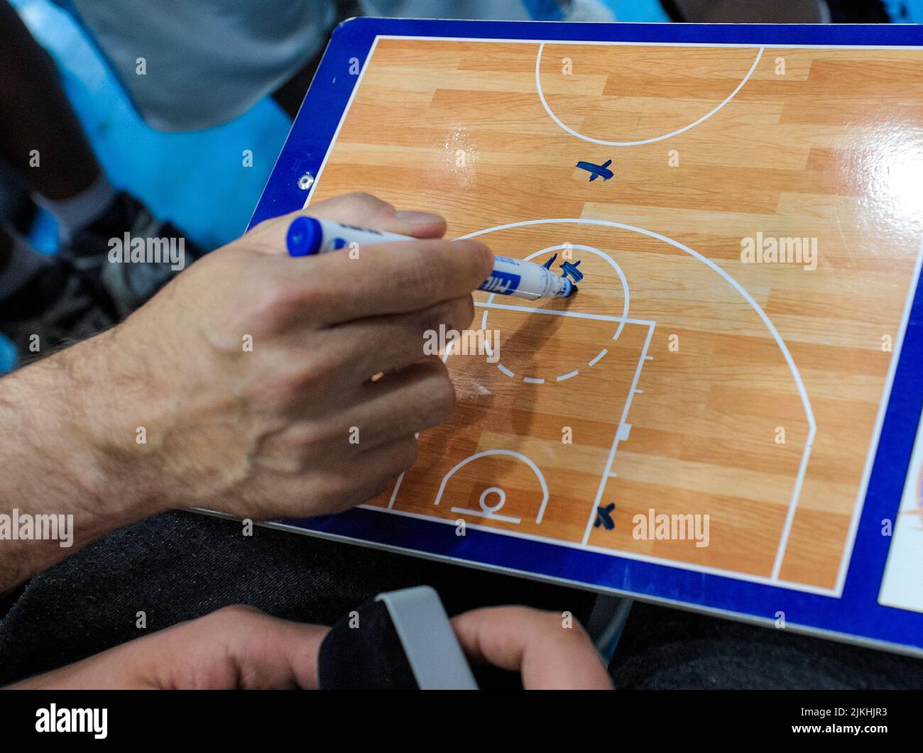 La mano di una persona con un marcatore che prende appunti su una tavola da campo di calcio - concetto di strategia di gioco Foto Stock