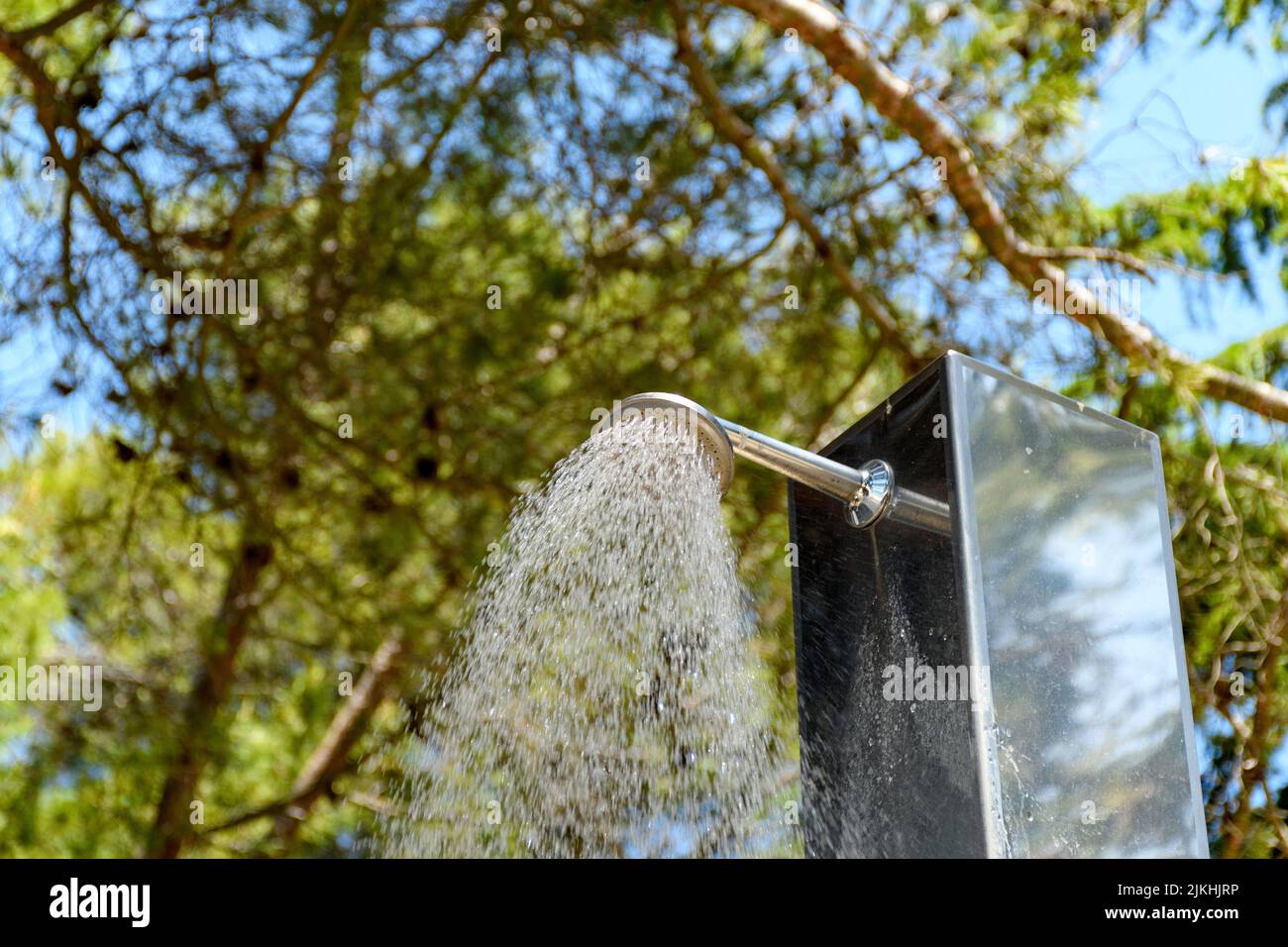 Un getto d'acqua che si riversa dalla doccia in spiaggia Foto Stock
