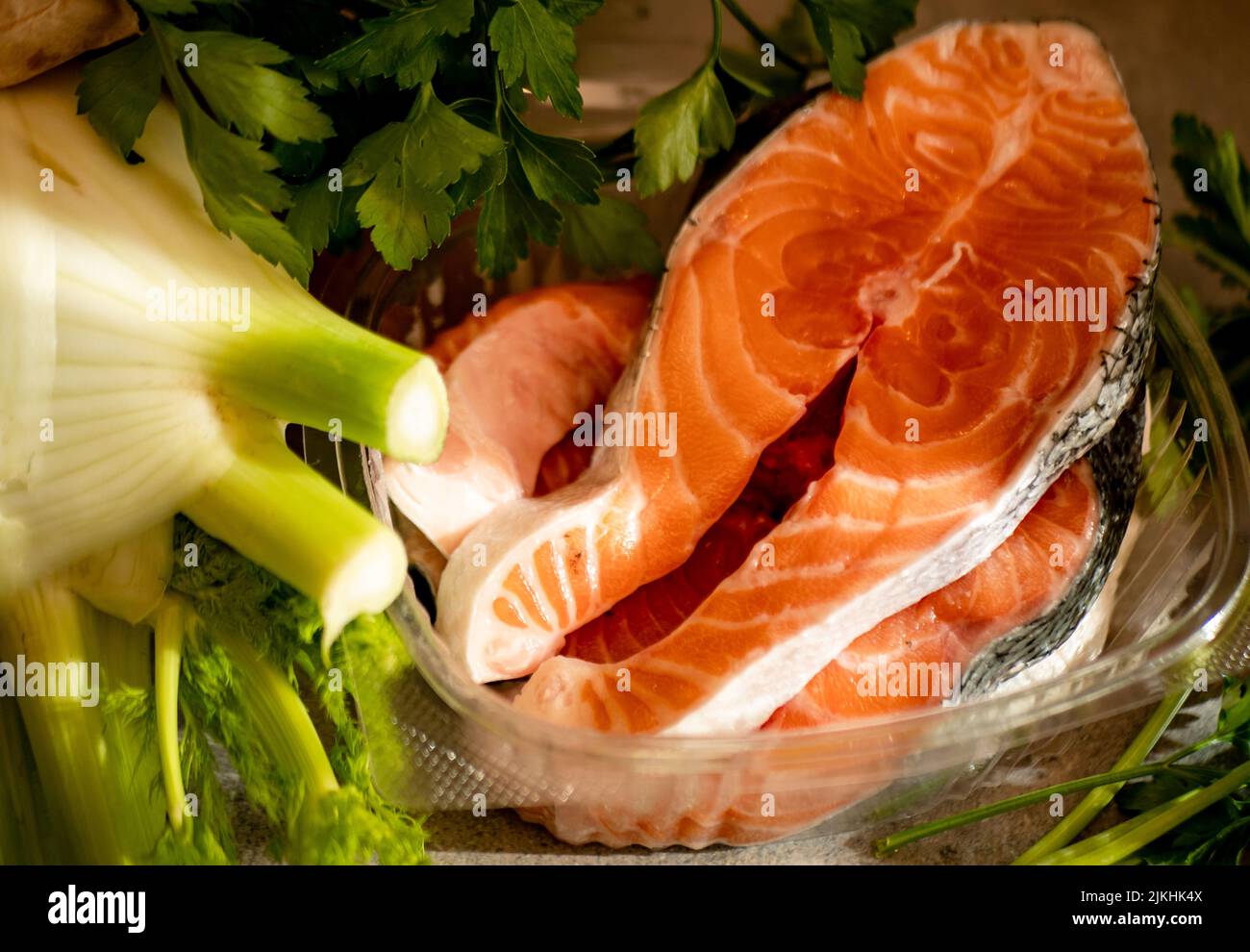 Bistecche di salmone fritte con verdure su tavolo di legno Foto Stock