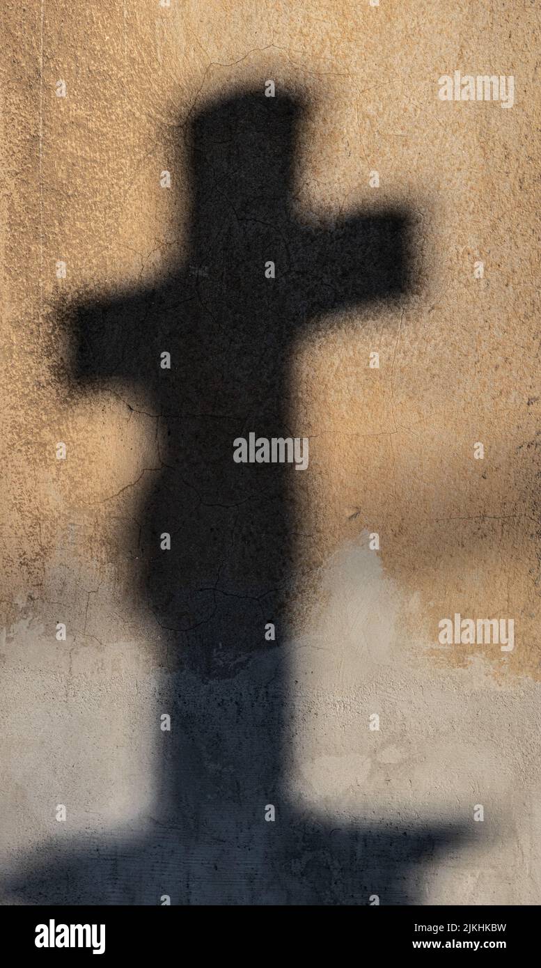 Immagine verticale di un'ombra di croce su una parete testurizzata Foto Stock