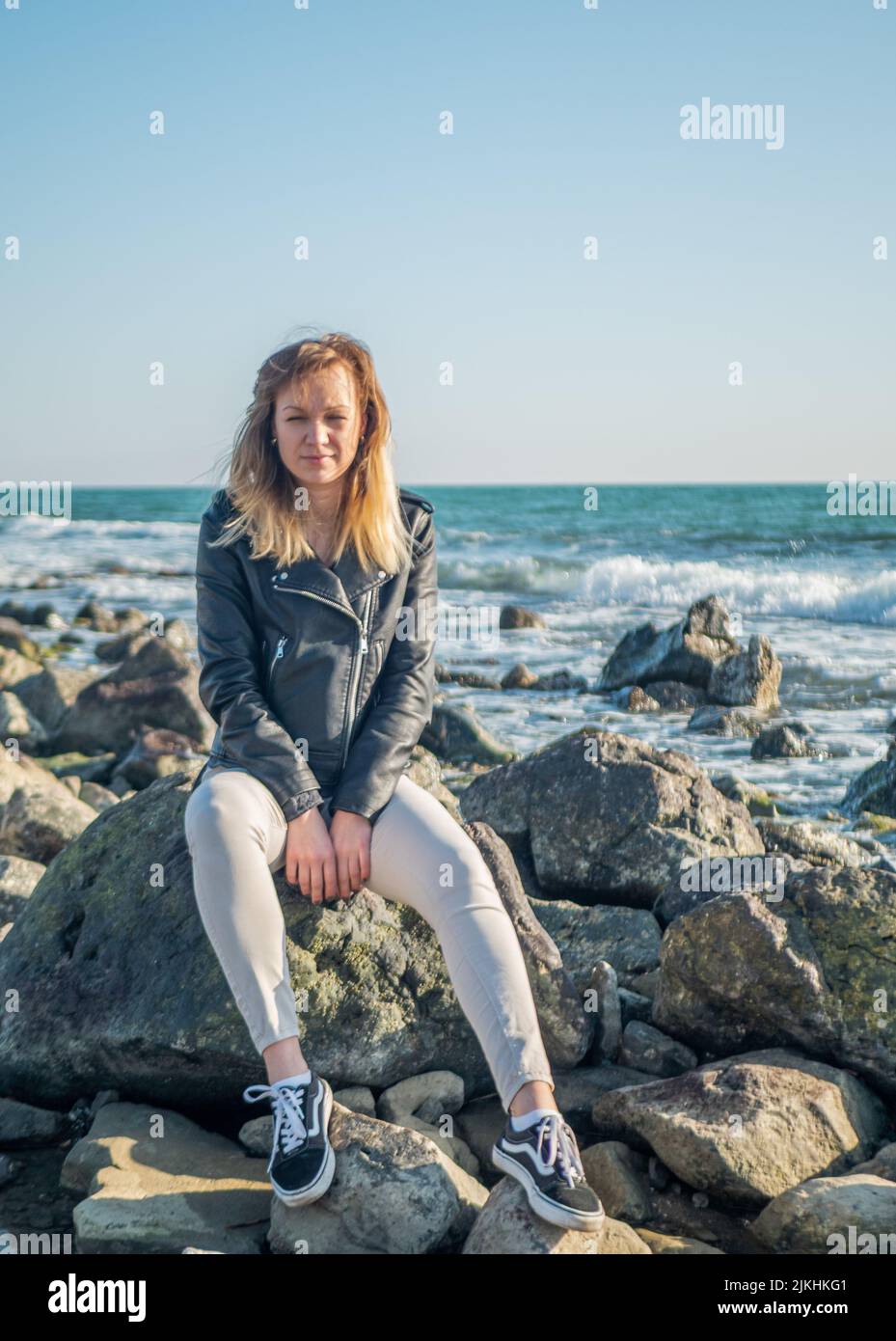 ritratto di una ragazza in piedi sulle rocce su uno sfondo del mare Foto Stock