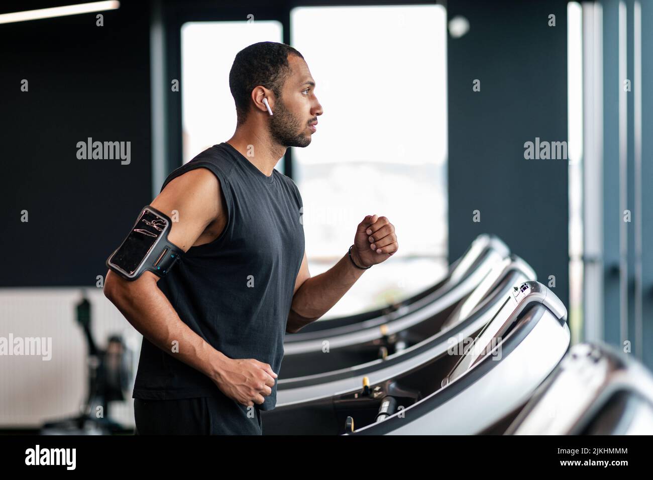 Allenamento sportivo. Motivato uomo afroamericano che usa il tapis roulant in palestra, Foto Stock