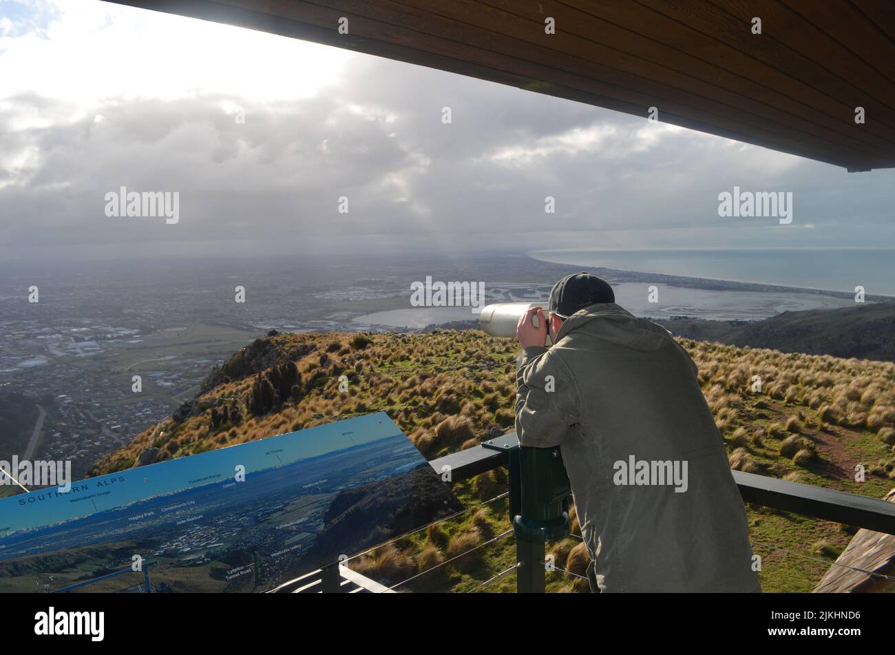 Un primo piano di un uomo che guarda il paesaggio attraverso il binocolo Foto Stock