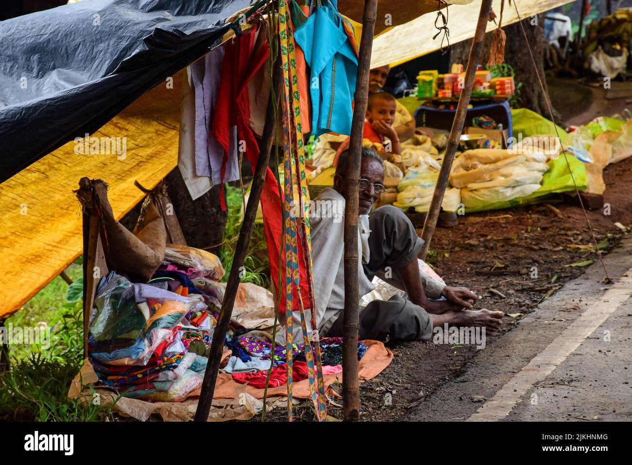 Kolhapur, India- Settembre 13th 2019; Stock photo di 60 a 70 vecchio uomo indiano seduta su strada e vendita di panni nel mercato settimanale della villa indiana Foto Stock