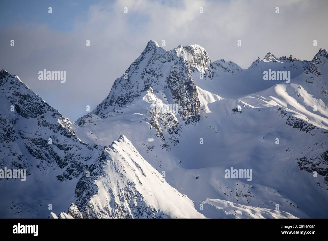 Una vista sulle montagne innevate che si illuminano alla luce del sole Foto Stock