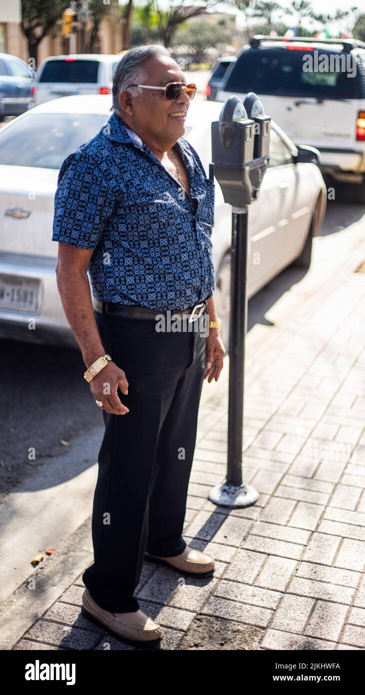 Un primo piano di un vecchio felice in piedi sulla strada in una giornata di sole Foto Stock