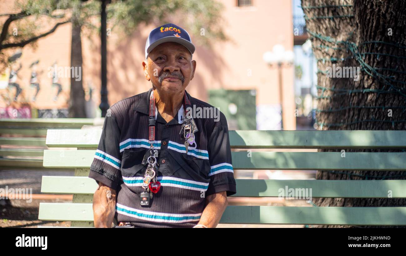Un ritratto di primo piano di un vecchio seduto su una panchina del parco Foto Stock
