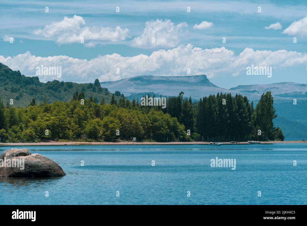 Un'incantevole vista sul mare circondata da alberi e montagne ad alta densità sullo sfondo Foto Stock