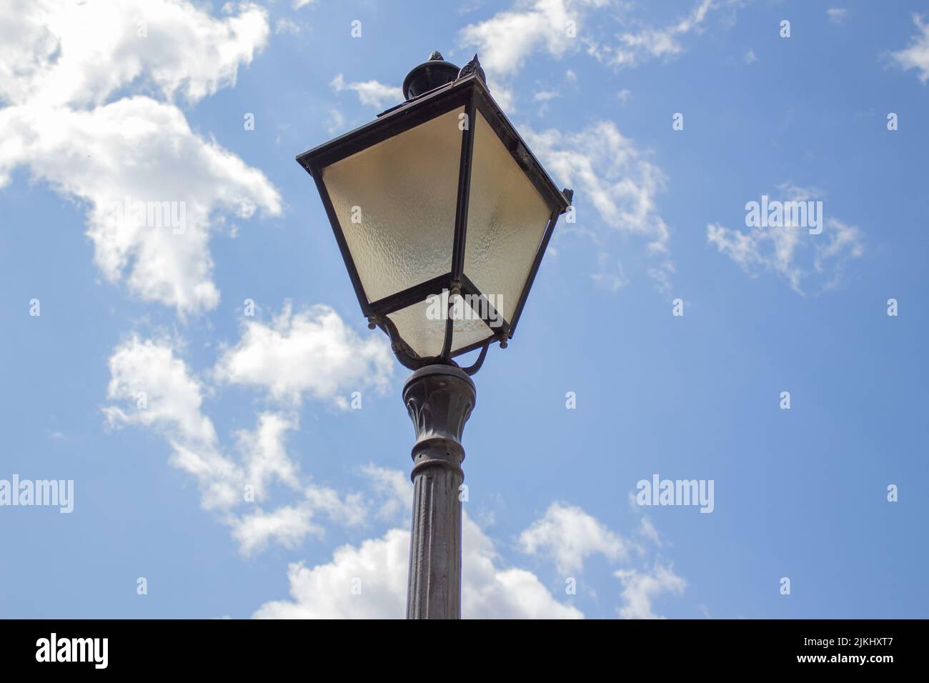 Un primo piano ad angolo basso di una lampada da strada contro il cielo blu. Foto Stock