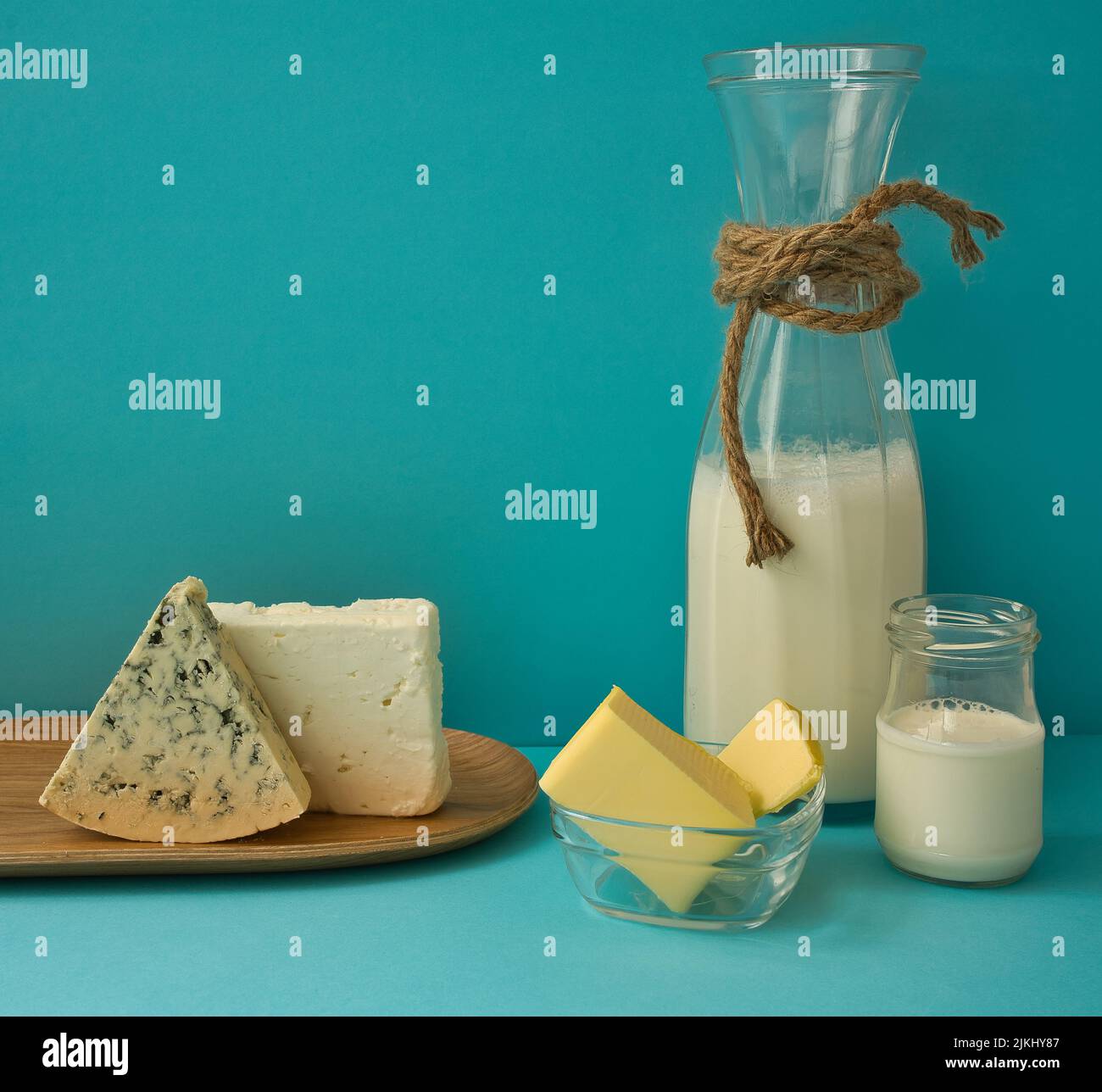 Diversi latticini su sfondo blu: Yogurt, formaggio, latte e uova. Vitamine solubili in acqua (B1, B2, niacina e acido folico) e solubili nei grassi v Foto Stock