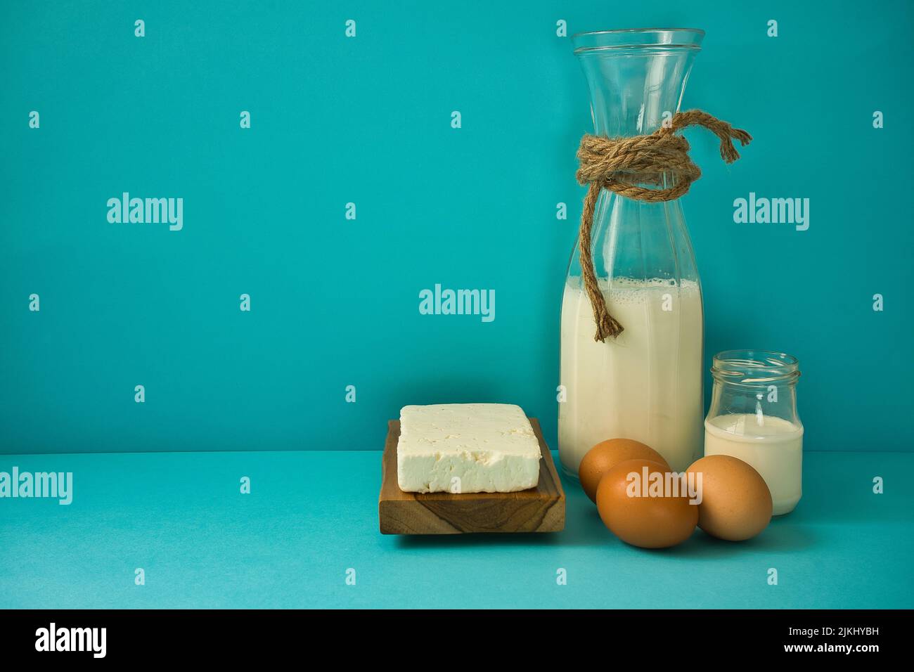 Diversi latticini su sfondo blu: Yogurt, formaggio, latte e uova. Vitamine solubili in acqua (B1, B2, niacina e acido folico) e solubili nei grassi v Foto Stock