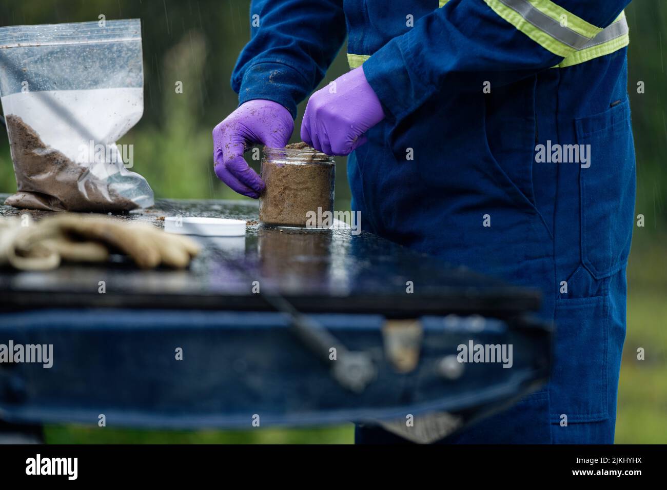 Un primo piano del lavoratore professionale che prova e campiona olio sabbie stagni di coda Foto Stock