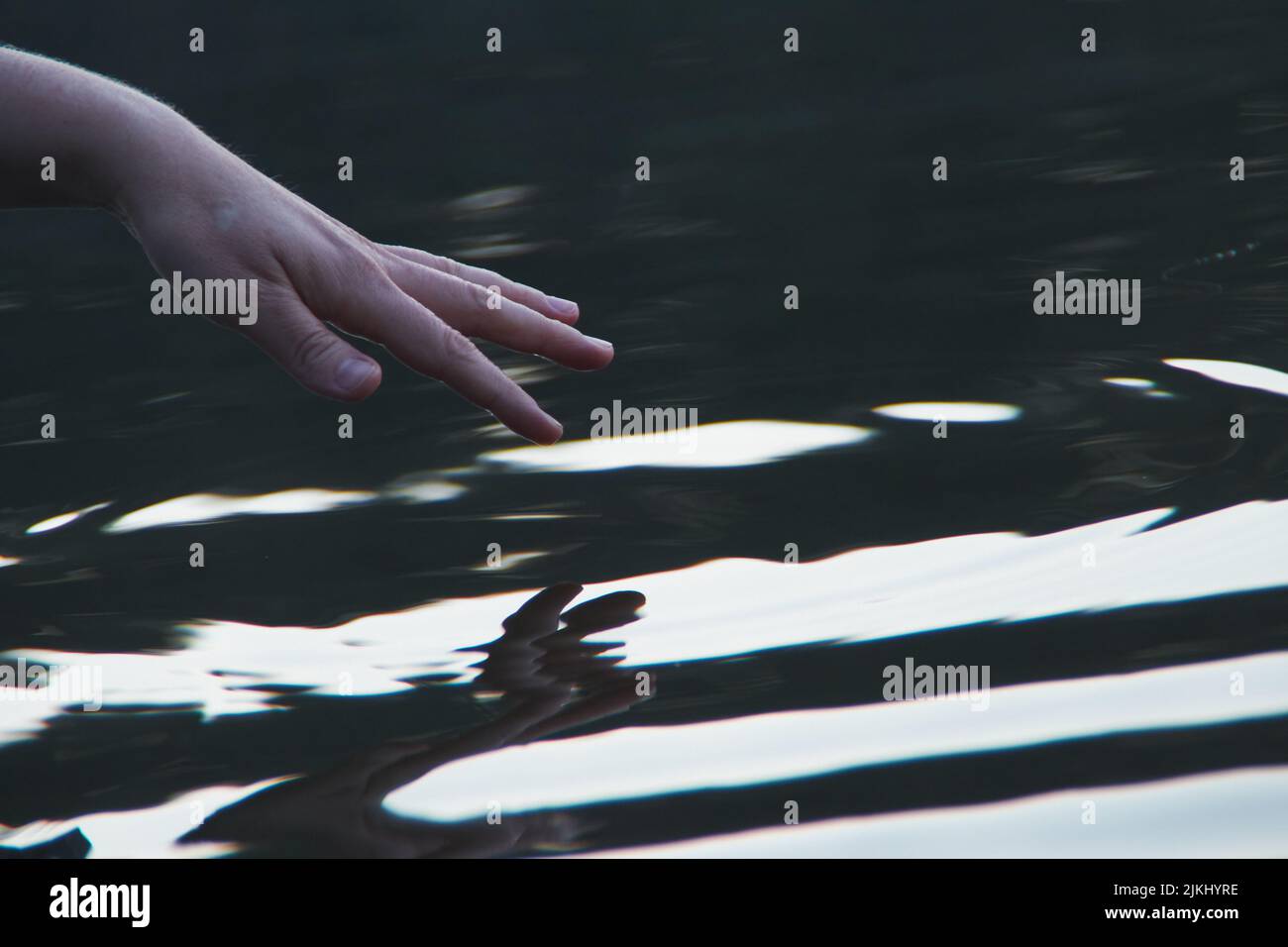 la donna tocca la superficie dell'acqua, la fotografia creativa Foto Stock