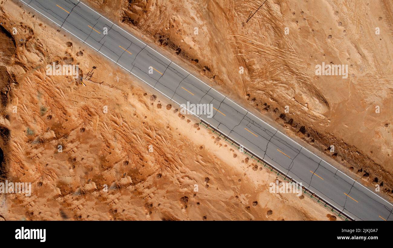 Una vista aerea dall'alto di una strada attraverso un deserto asciutto Foto Stock