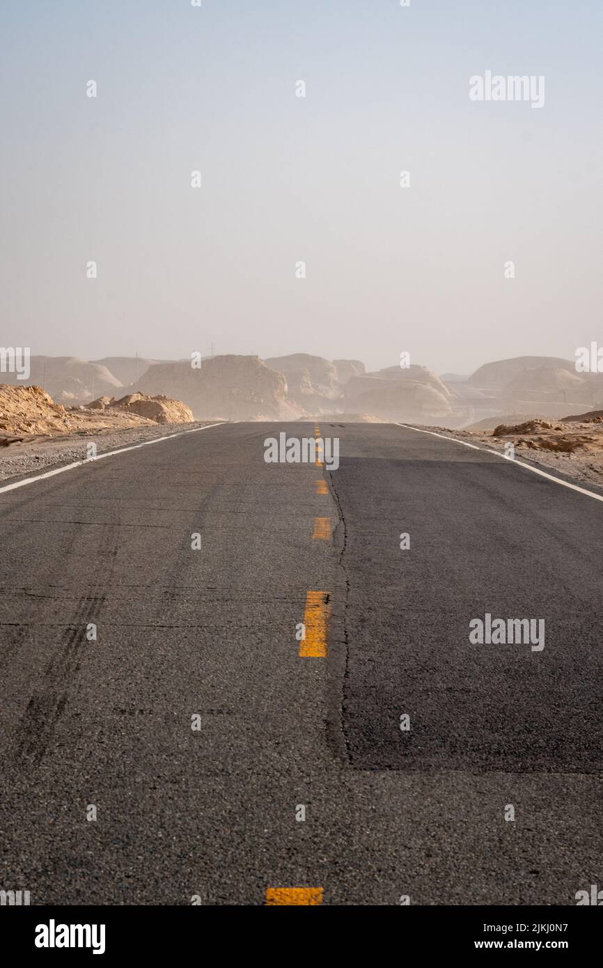 Una strada vuota e senza fine attraverso il deserto Foto Stock