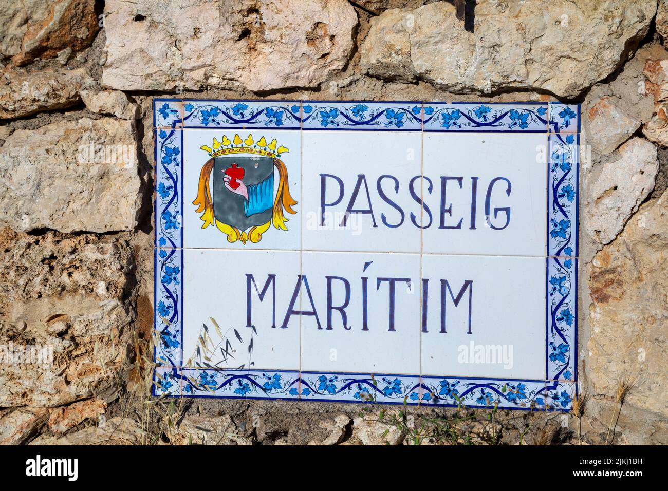 Spagna, Isole Baleari, Maiorca, distretto di Manacor, Calas de Mallorca. Scritta decorata in maiolica, tradizionale per indicare il nome delle strade alle Isole Baleari, Passeig Maritim Foto Stock