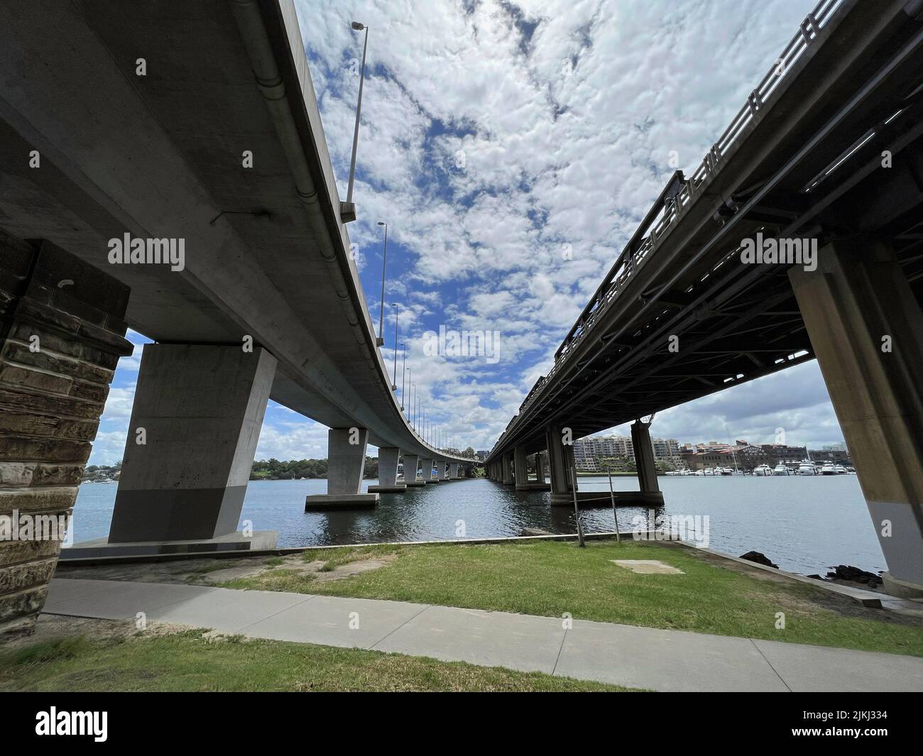 Vista tra due ponti, il ponte pedonale Iron Cove Creek e il ponte Iron Cove Bridge at Bay Run, Sydney, NSW Australia Foto Stock
