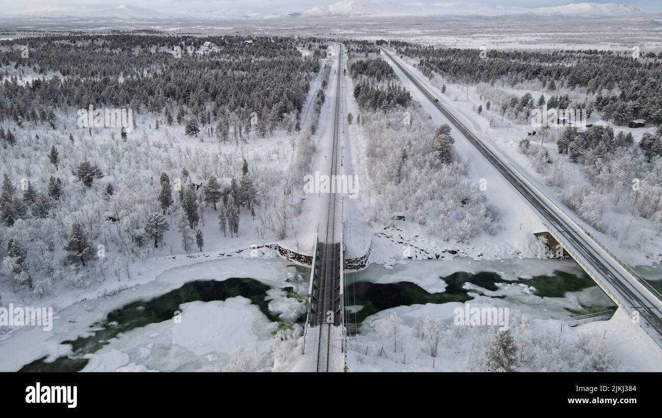 Vista dall'alto delle lunghe ferrovie che attraversano la foresta in inverno Foto Stock