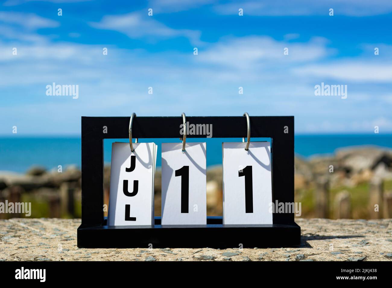 Lug 11 calendario data testo su cornice di legno con sfondo sfocato di oceano. Informazioni sulla data del calendario. Foto Stock