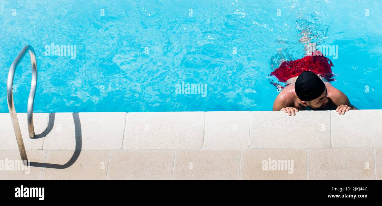 Una vista dall'alto di un uomo ispanico in piscina in una giornata di sole in Colombia Foto Stock