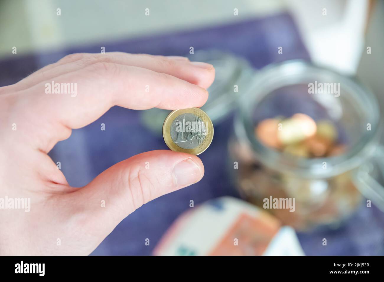 Il focus selettivo delle monete da 1 euro in mano - la raccolta di denaro per gli investimenti Foto Stock
