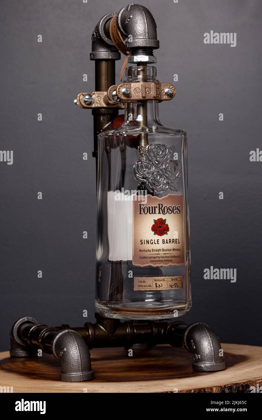 Una foto verticale di quattro rose Steampunk bourbon bottiglia lampada tubo Foto Stock