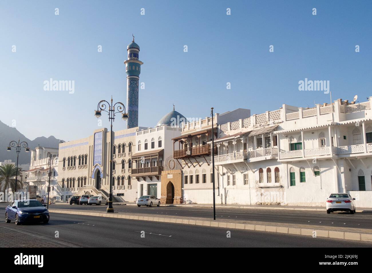 Le belle case e l'iconica moschea blu presso la Mutrah Corniche con la strada senza traffico Foto Stock