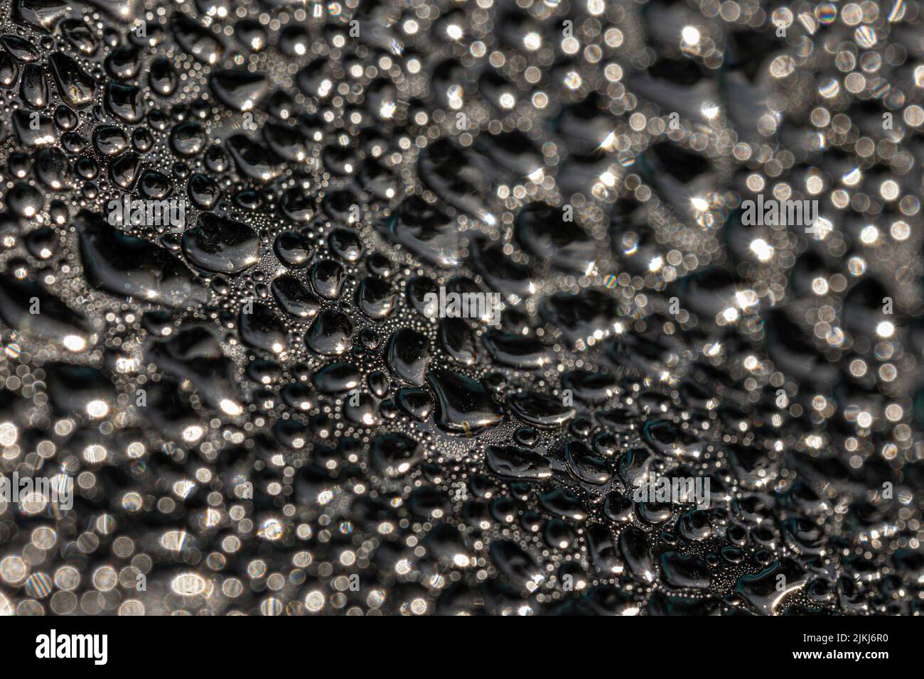 Un colpo selettivo di bolle grandi e piccole in un bicchiere come sfondo Foto Stock