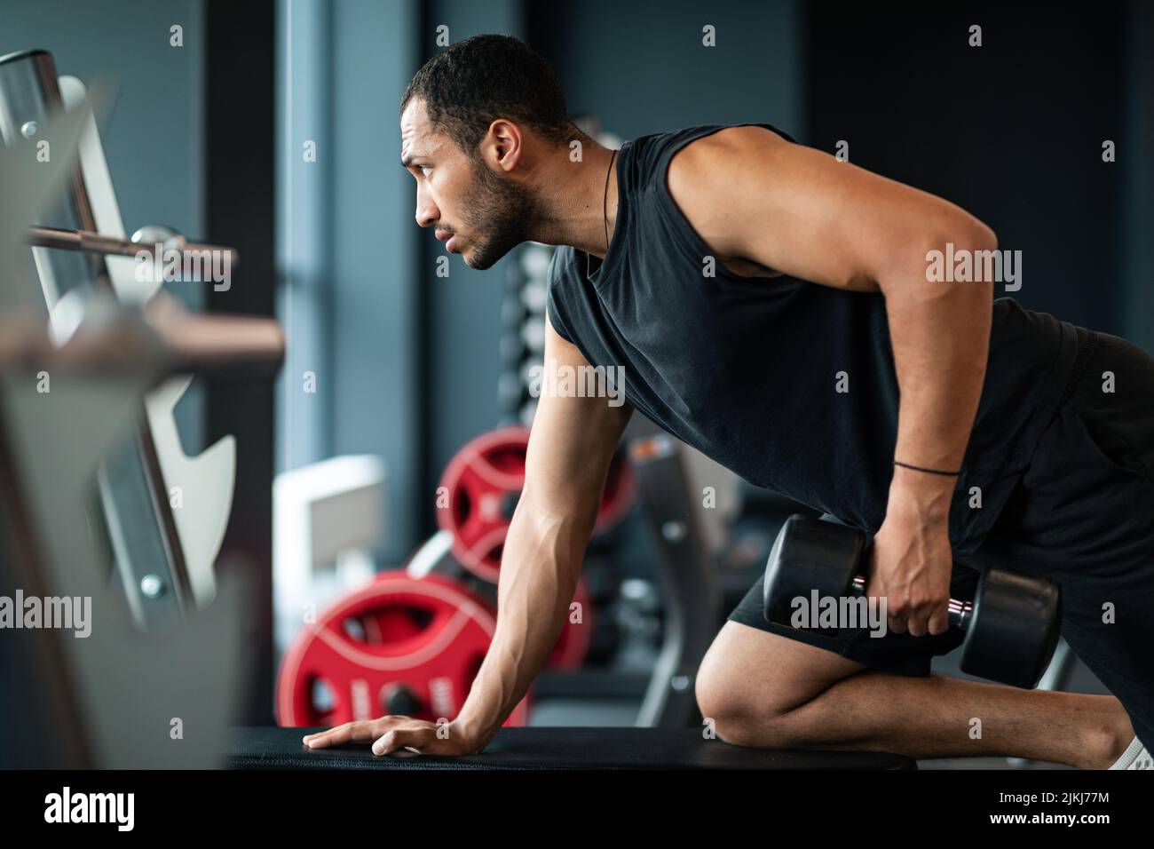 Giovane African American Sportsman Training con Dumbbell all'interno della palestra Foto Stock