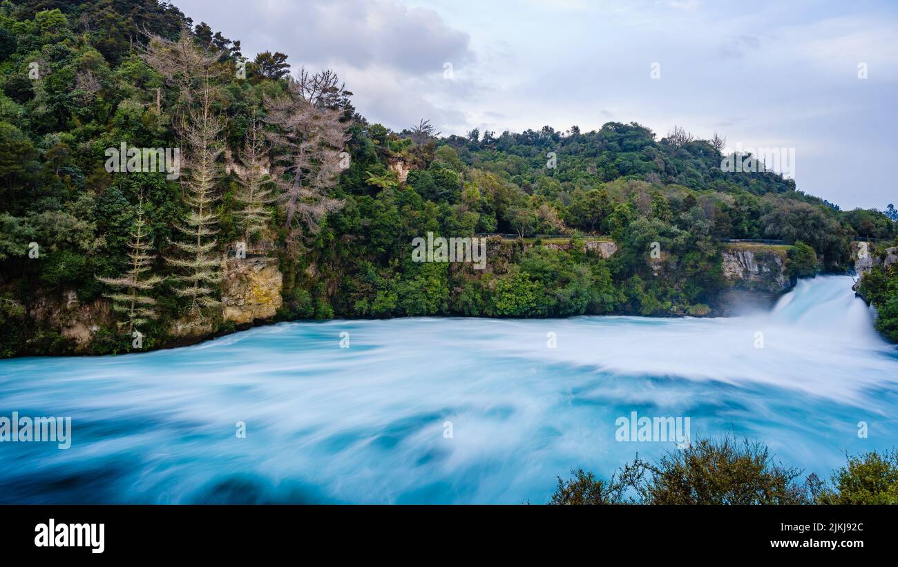 Una splendida vista delle cascate di Huka circondate da alberi in Nuova Zelanda Foto Stock
