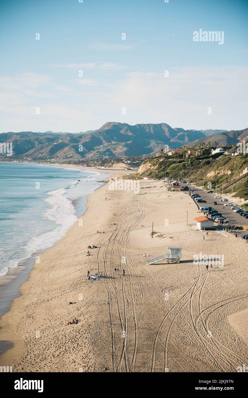 Una vista aerea della spiaggia di Zuma e delle montagne contro il cielo blu in una giornata di sole a Malibu, California, Stati Uniti Foto Stock
