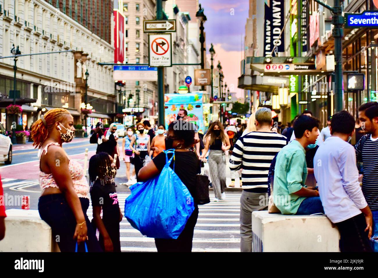 Una vista vivace della città sulle strade durante l'ora della corona con maschere in estate a NYC, 7th Avenue Foto Stock