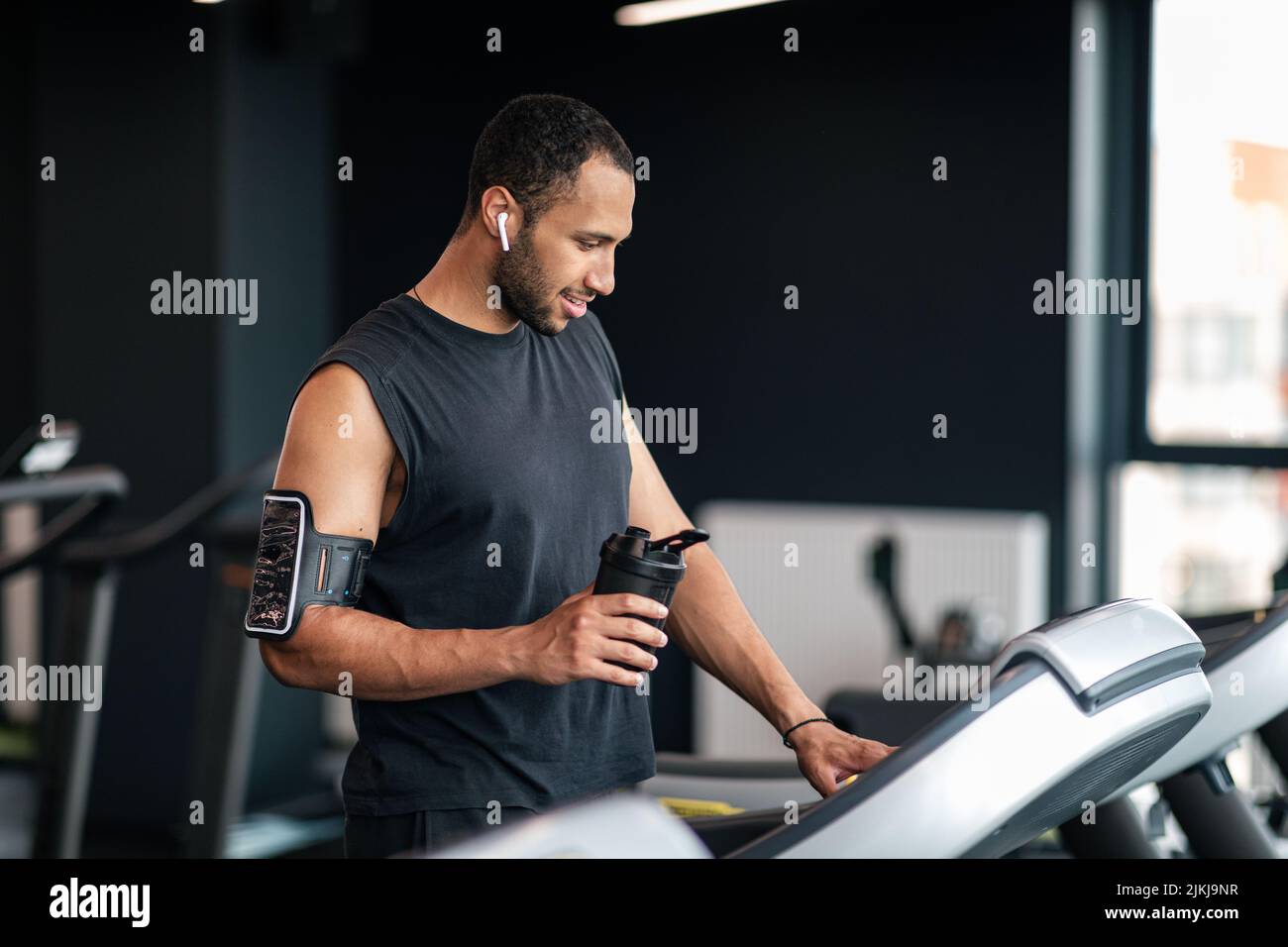 Allenamento jogging. Ritratto di sportivo Afro American Man utilizzando Treadmill in palestra Foto Stock