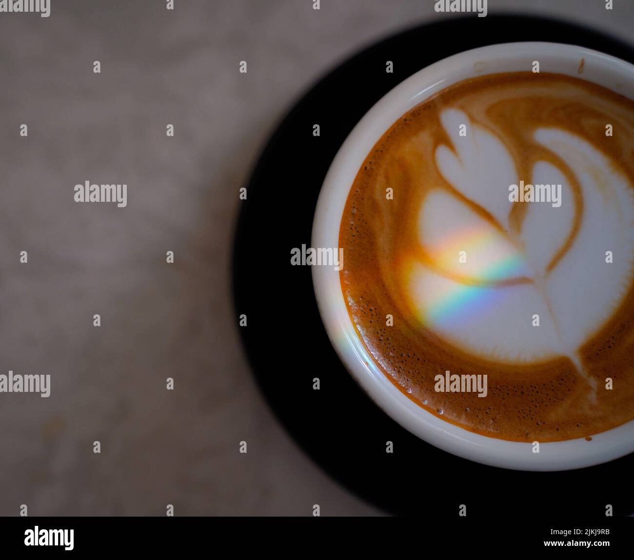 Una vista dall'alto di un caffè del sabato Cappuccino con un design sopra il latte e la luce primaverile del mattino Foto Stock