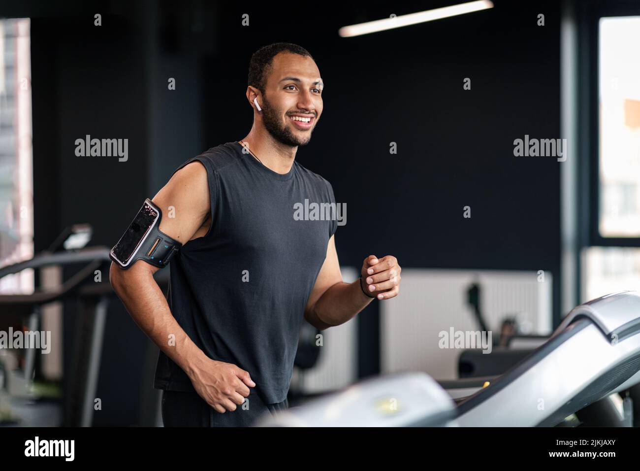 Ritratto del bel atleta maschio nero che si esercita sul tapis roulant in palestra Foto Stock