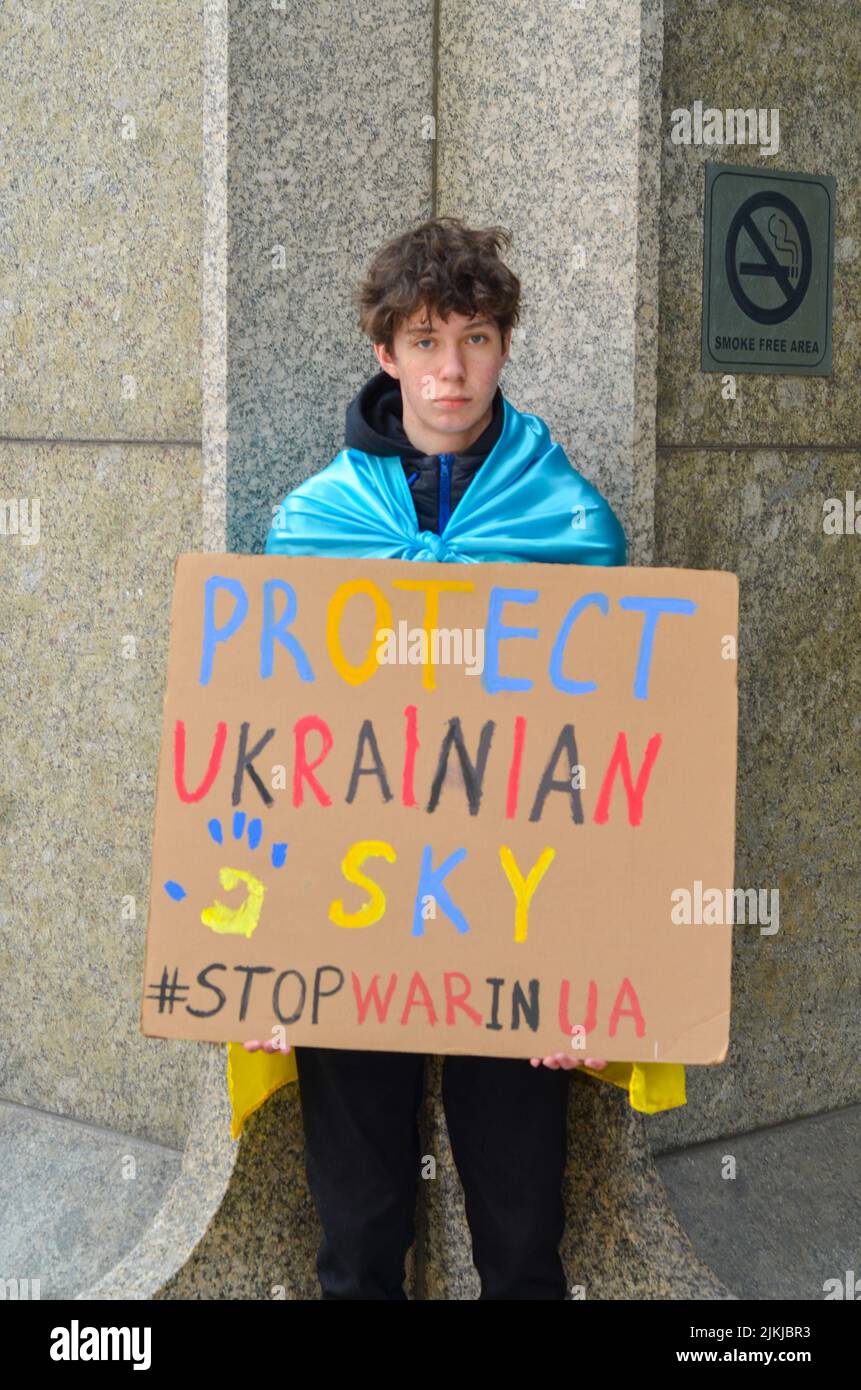 Un giovane dimostratore ha un segnale per chiedere protezione al popolo ucraino di fronte al United Nations Plaza di New York il 26 marzo 2022. Foto Stock