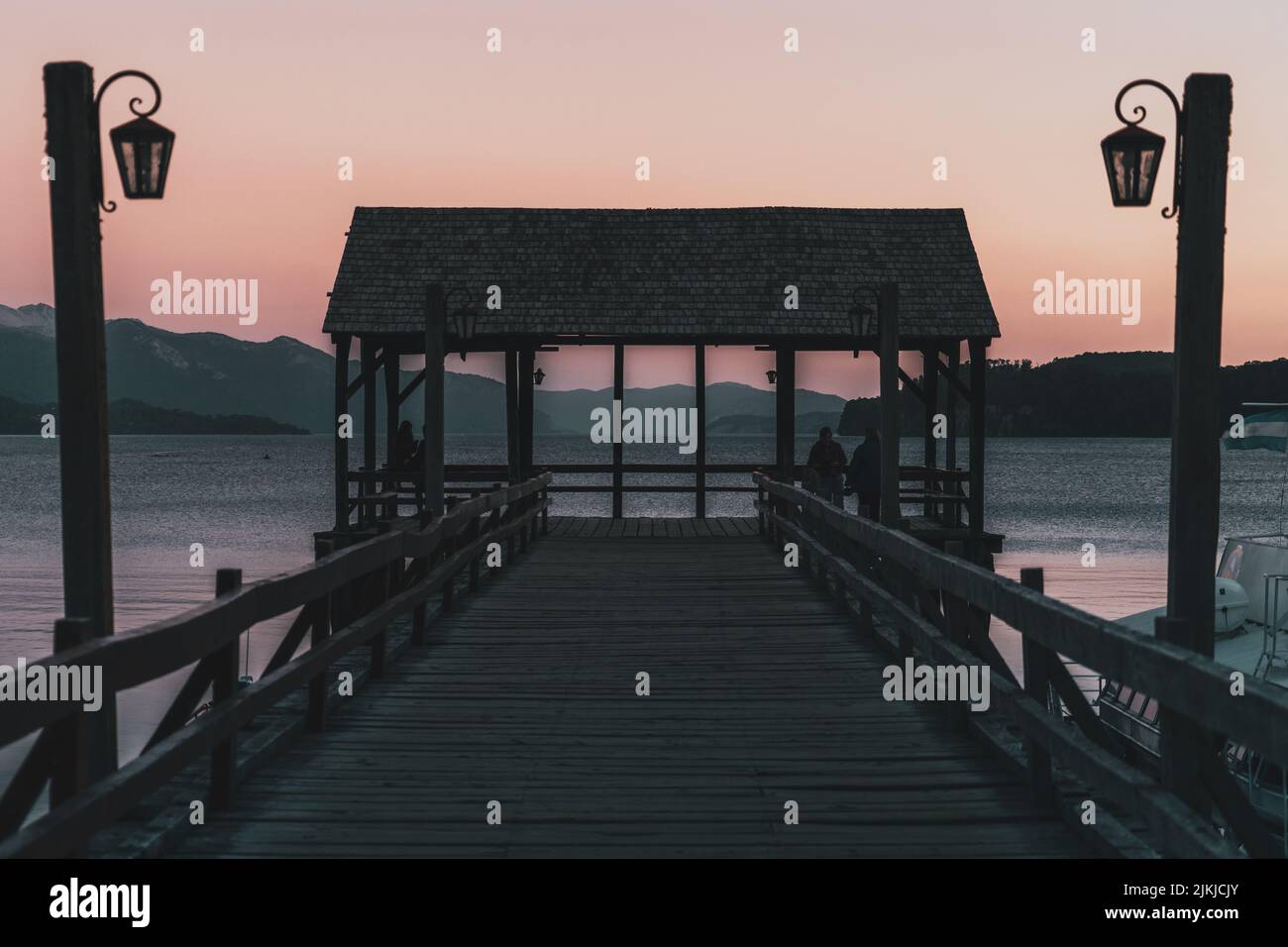 Una bella vista di persone che godono della vista del fiume in piedi su un molo di legno Foto Stock