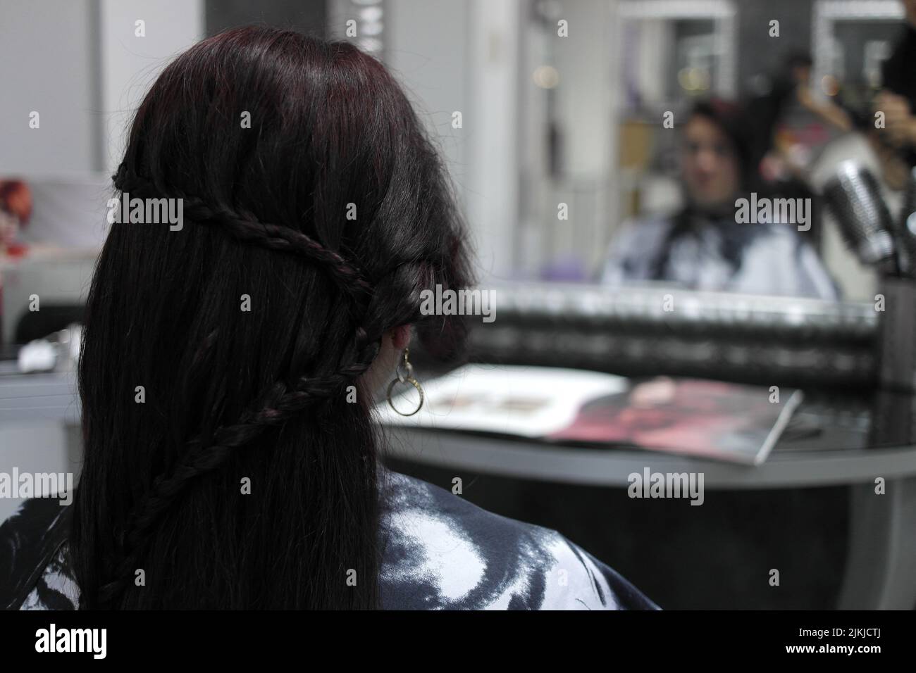 Un fuoco poco profondo di una donna ad un salone dei capelli con acconciatura intrecciata fantasia Foto Stock