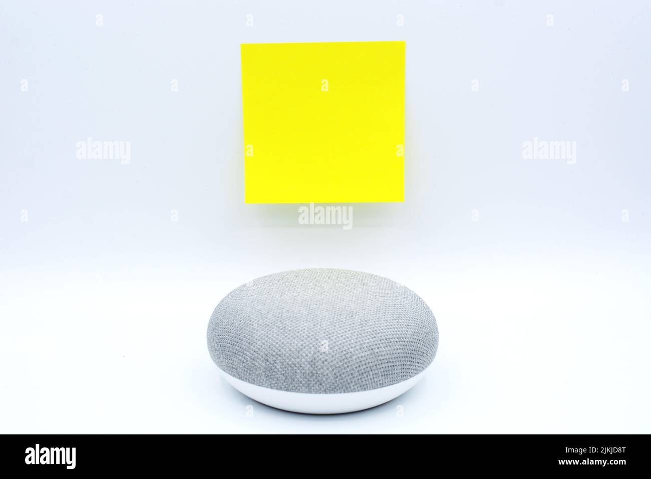 Un altoparlante domestico intelligente isolato su sfondo bianco con un post-it con spazio di copia sopra Foto Stock