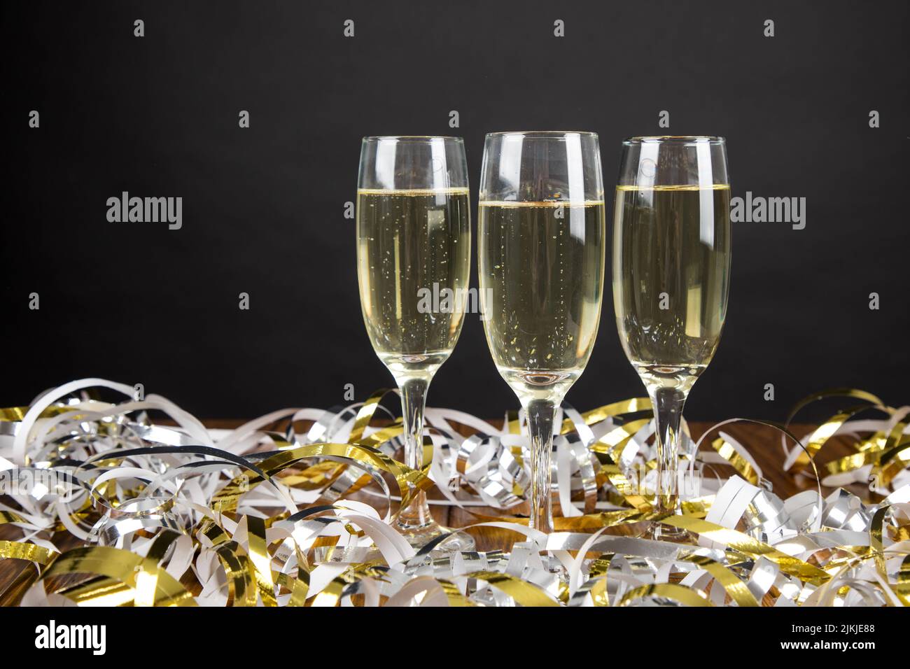 Un primo piano di un bicchiere di champagne con gli streamer alla festa di Capodanno Foto Stock