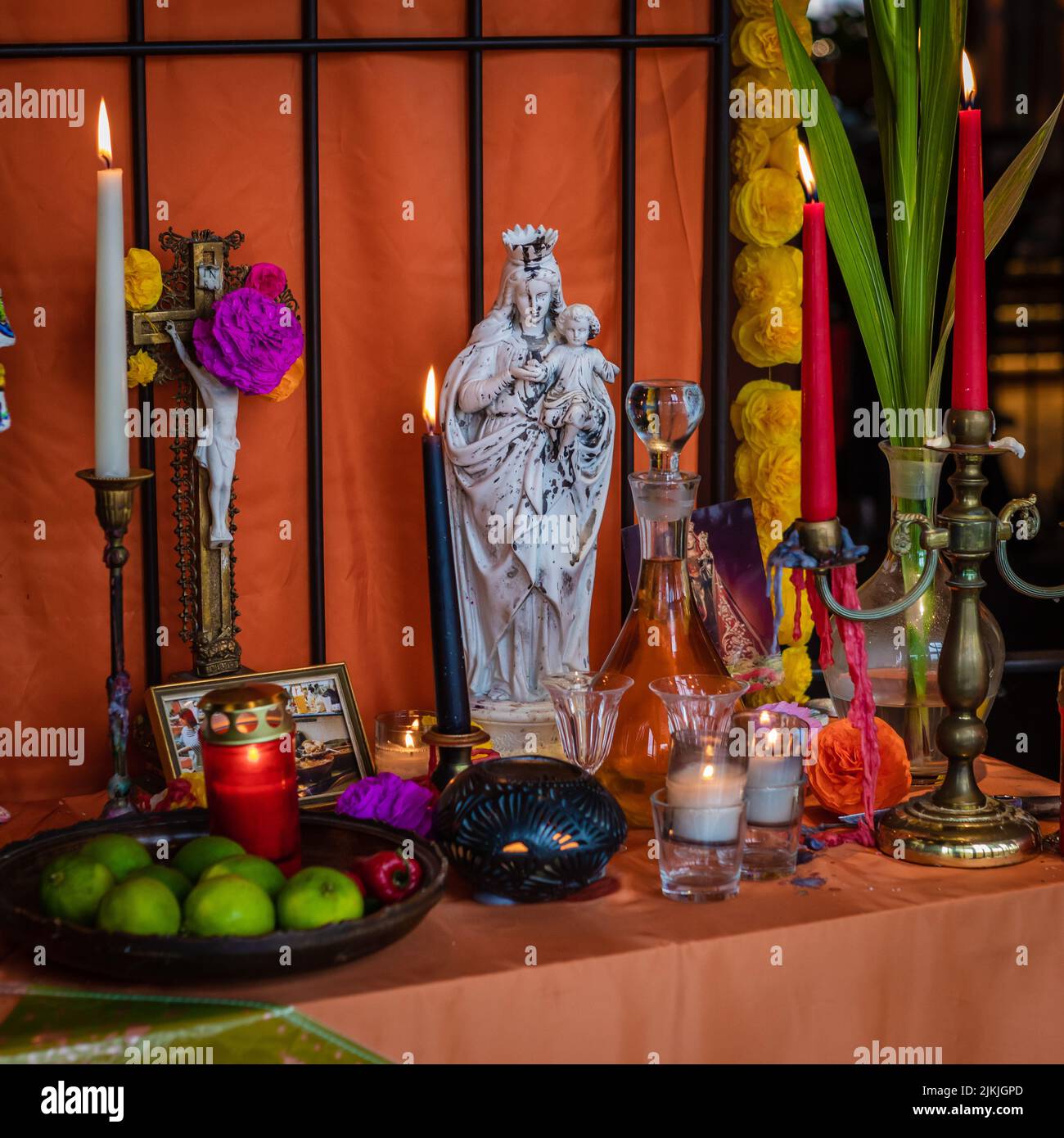 Un allestimento di dia De Los Muertos decor con candele e una statua di Santa Maria Foto Stock